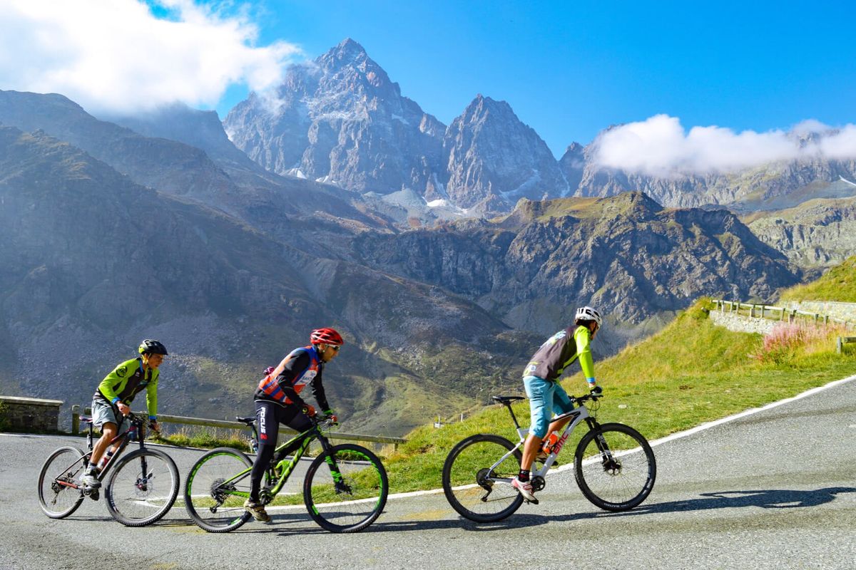 Ciclisti affrontano una salita in MTB su asfalto nelle terre del monviso, nella zona di cuneo in piemonte
